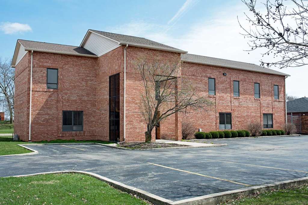 Red brick commercial building with parking lot