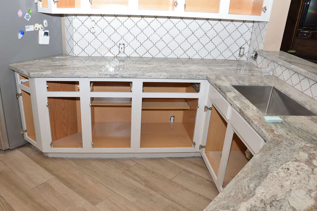 Open wood cabinets with granite countertops